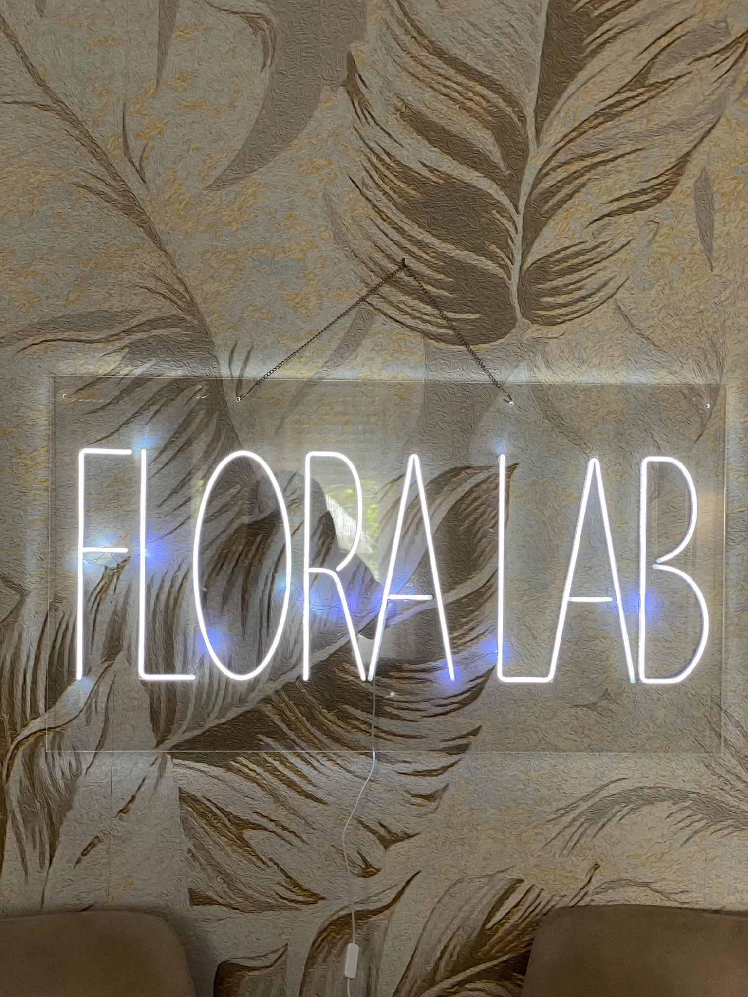 Neonska reklama „FLORA LAB“ na providnom pleksiglasu