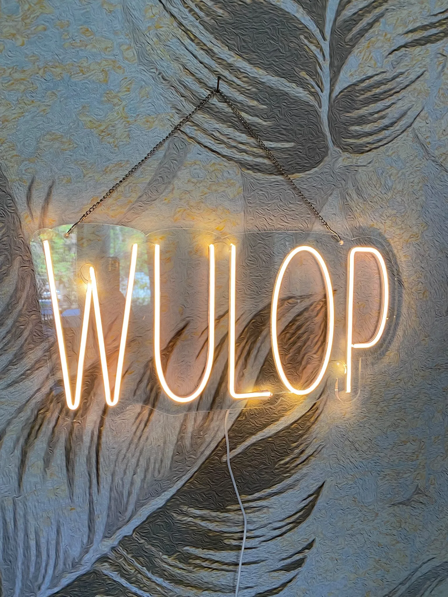 Neonska reklama sa nazivom „WULOP“ u toplom svetlu