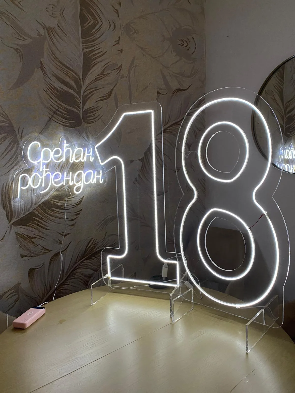 Neonski broj 18 od providnog pleksiglasa i neonski natpis „Срећан рођендан“