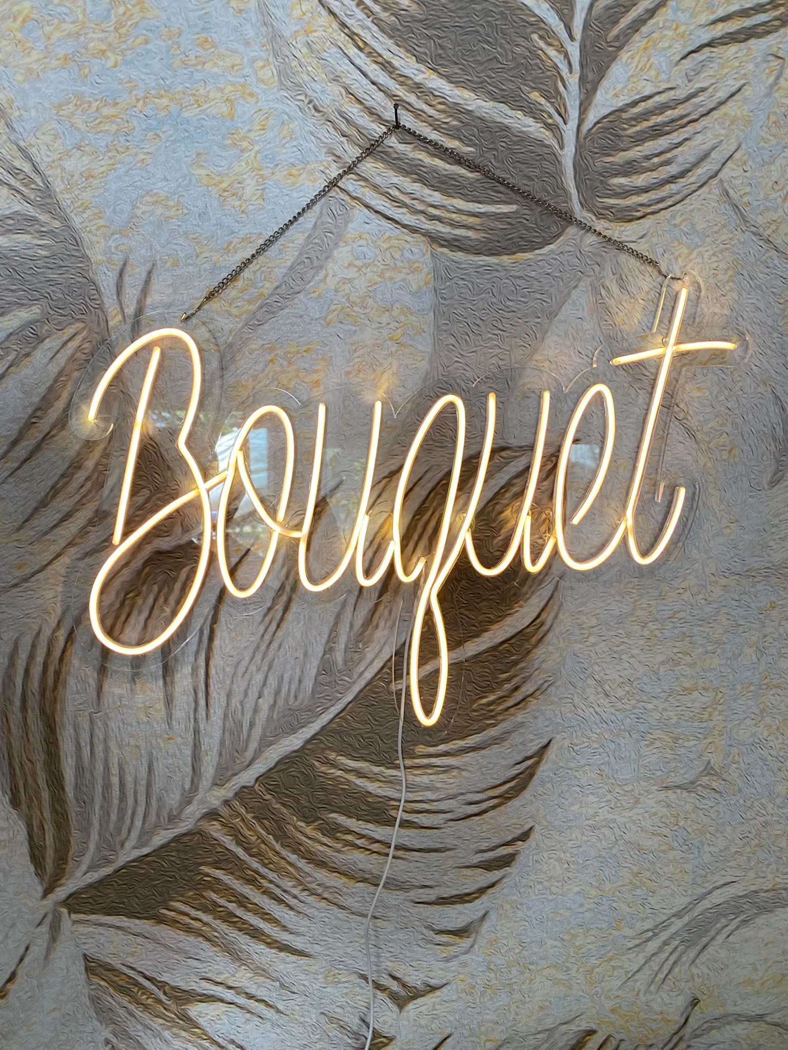 Neonski natpis „Bouquet“ na providnom pleksiglasu, za cvećaru
